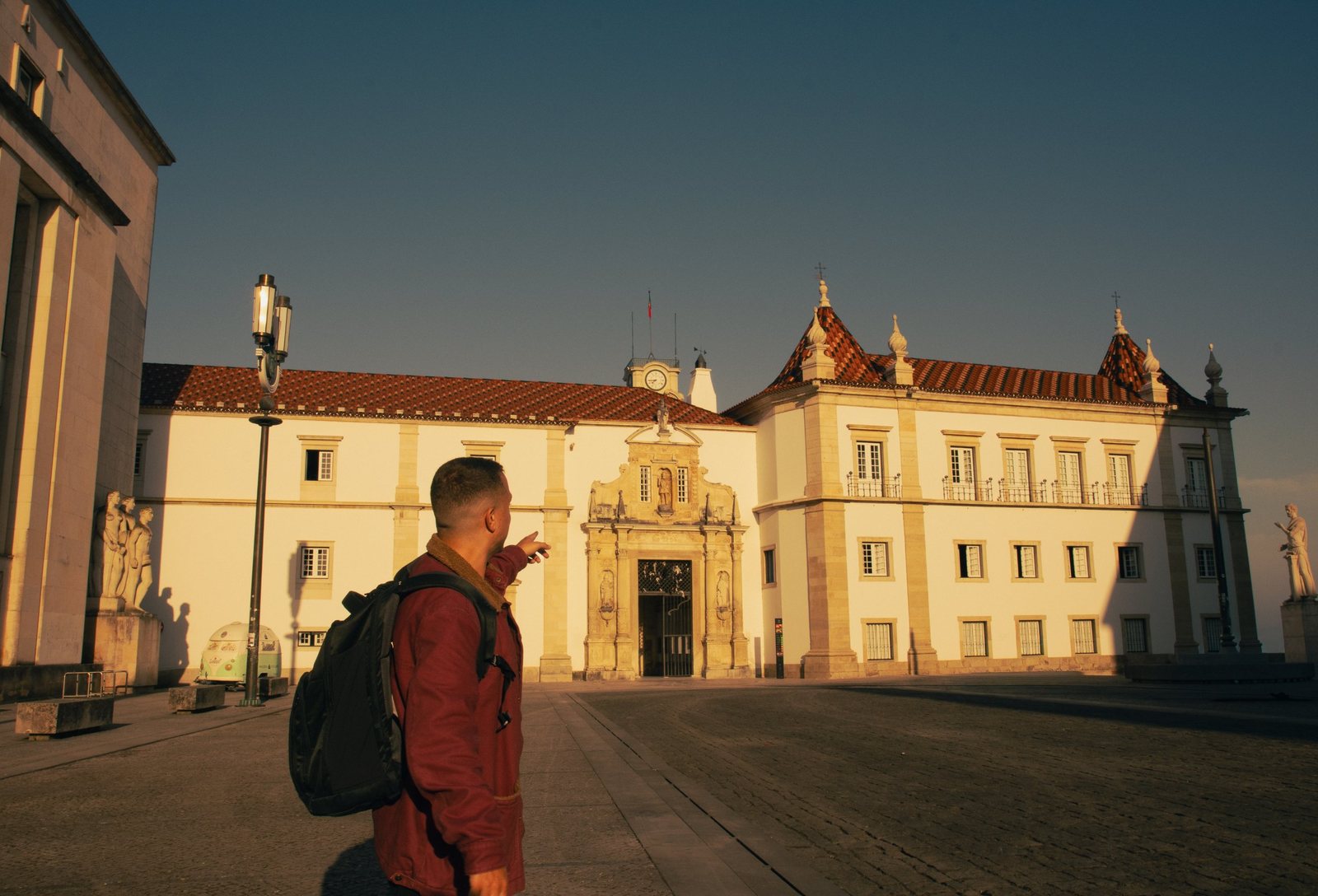 Breno, with his black backpack, pointing at the University of Coimbra